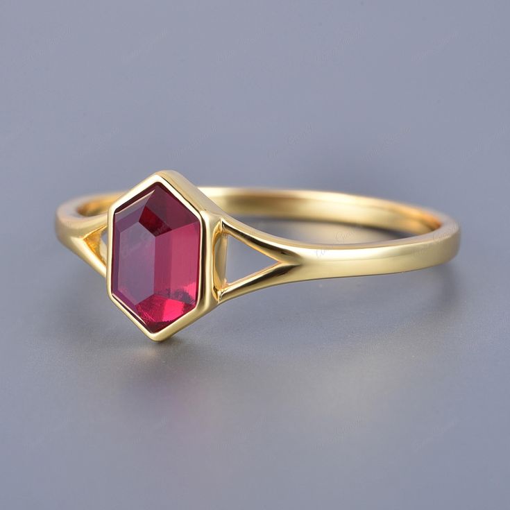 This exquisite ruby ring is a perfect blend of timeless elegance and modern design. Featuring a unique hexagon-cut ruby, this solitaire ring is crafted with a vintage bezel setting in solid 14k yellow gold. The vibrant red hue of the ruby is beautifully complemented by the warm glow of the gold, making it a stunning piece for any occasion. Whether it's an engagement, anniversary, or a special gift, this ring is designed to make a lasting impression. The sophisticated bezel setting not only enhan Ruby Bezel Ring, Octagon Ruby Ring Fine Jewelry, Octagon Ruby Ring In Fine Jewelry Style, Classic Octagon Ruby Ring, Elegant Faceted Ruby Promise Ring, Octagon-shaped Red Ruby Ring, Red Octagon Ruby Ring, Ruby Ring Vintage, Garnet Engagement Ring