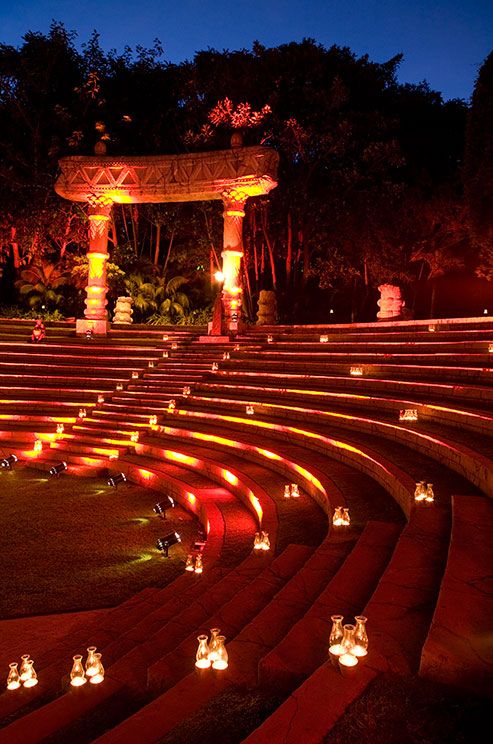 many lit candles are placed in the middle of a circular area with steps leading up to it