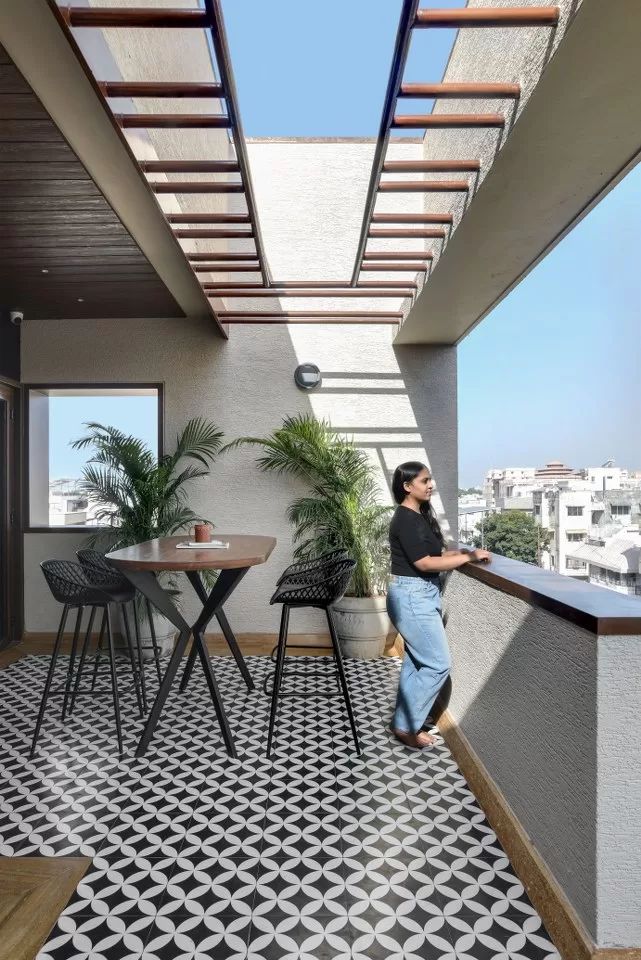 a woman is standing on the balcony looking out at the city from her apartment building