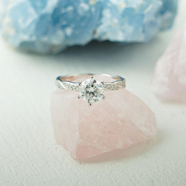 a diamond ring sitting on top of a pink rock