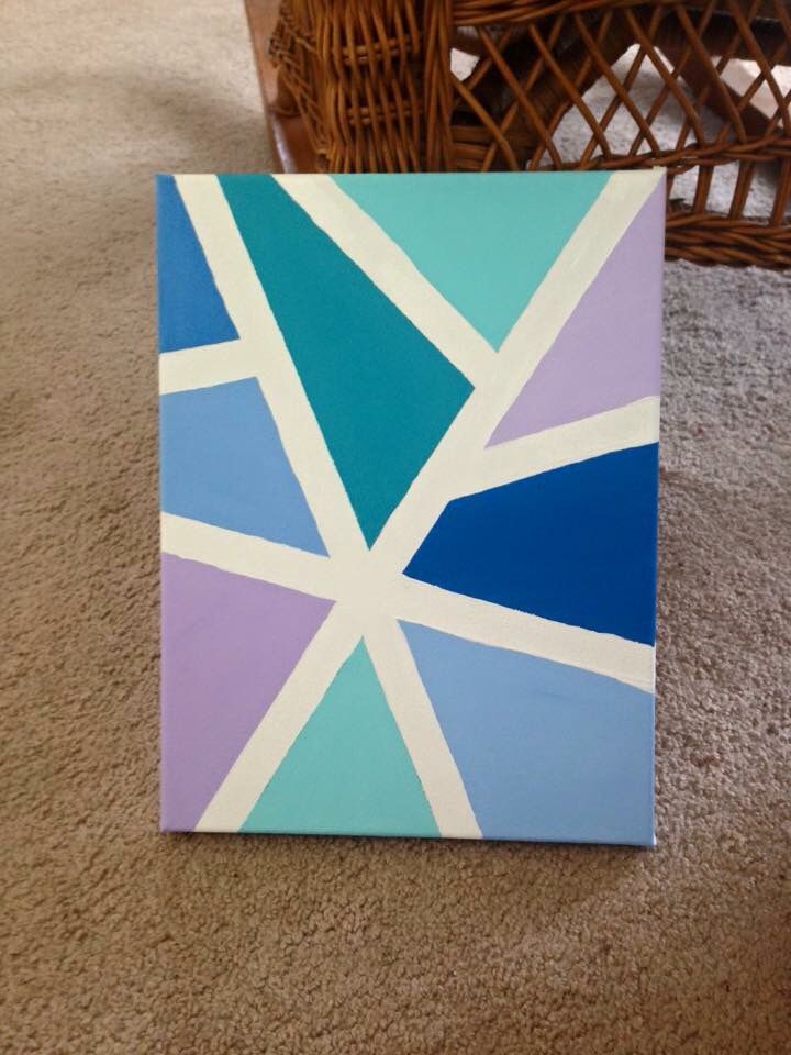 a blue and purple painting sitting on top of a carpeted floor next to a wicker basket