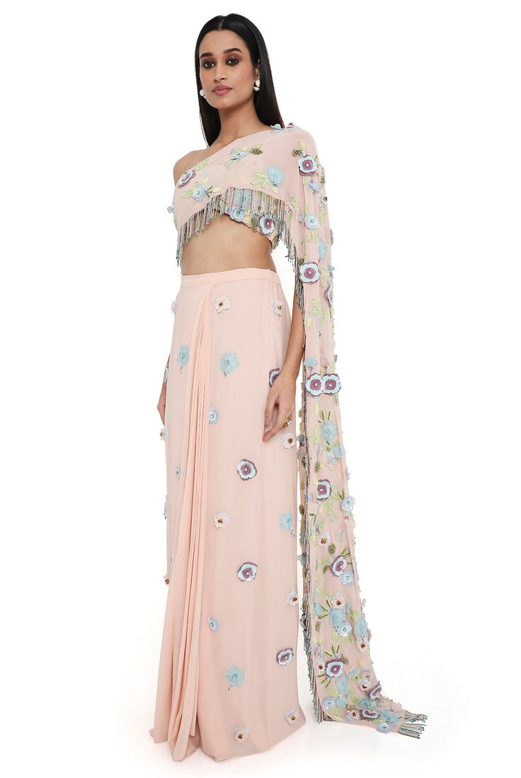 Blush pink georgette embroidered choli with attached pallu with hanging colorful tassels and embroidered pre-stitched skirt. Disclaimer: Since we are a made-to-measure brand and our dyeing process and embroidery are handcrafted, there may be slight variations in the color and embroidery of the actual product. The print placement may also vary from what is represented in the images shown on the product page. Pink Embellished Pre-draped Saree For Navratri, Embellished Pink Pre-draped Saree For Navratri, Designer Floor-length Sets With Tassels, Festive Pink Sharara With Tassels, Designer Tassel Dresses For Navratri, Festive Pink Tassel Sharara, Pink Embellished Pre-draped Saree For Festivals, Embellished Pink Pre-draped Saree For Festivals, Designer Pre-draped Saree With Tassels