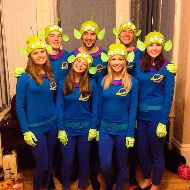 a group of people dressed in blue and green costumes posing for a photo with each other