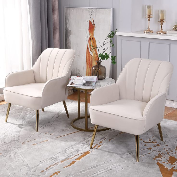 two white chairs sitting next to each other on top of a rug in a living room