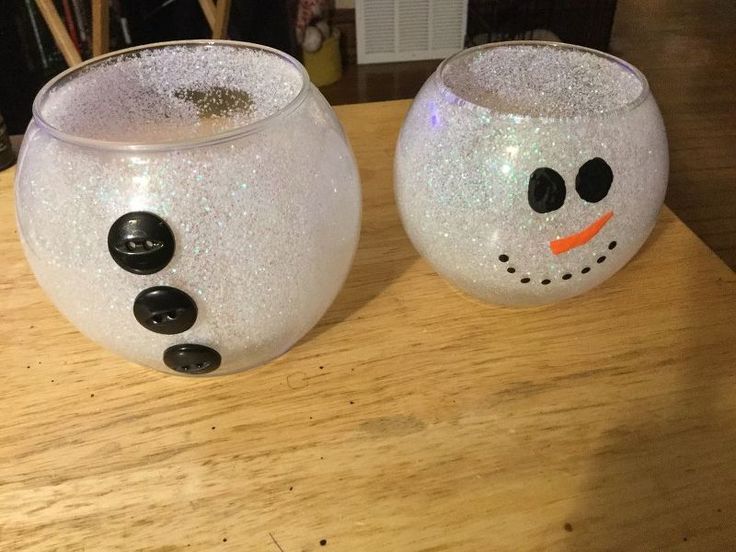 two snowman glasses sitting on top of a wooden table