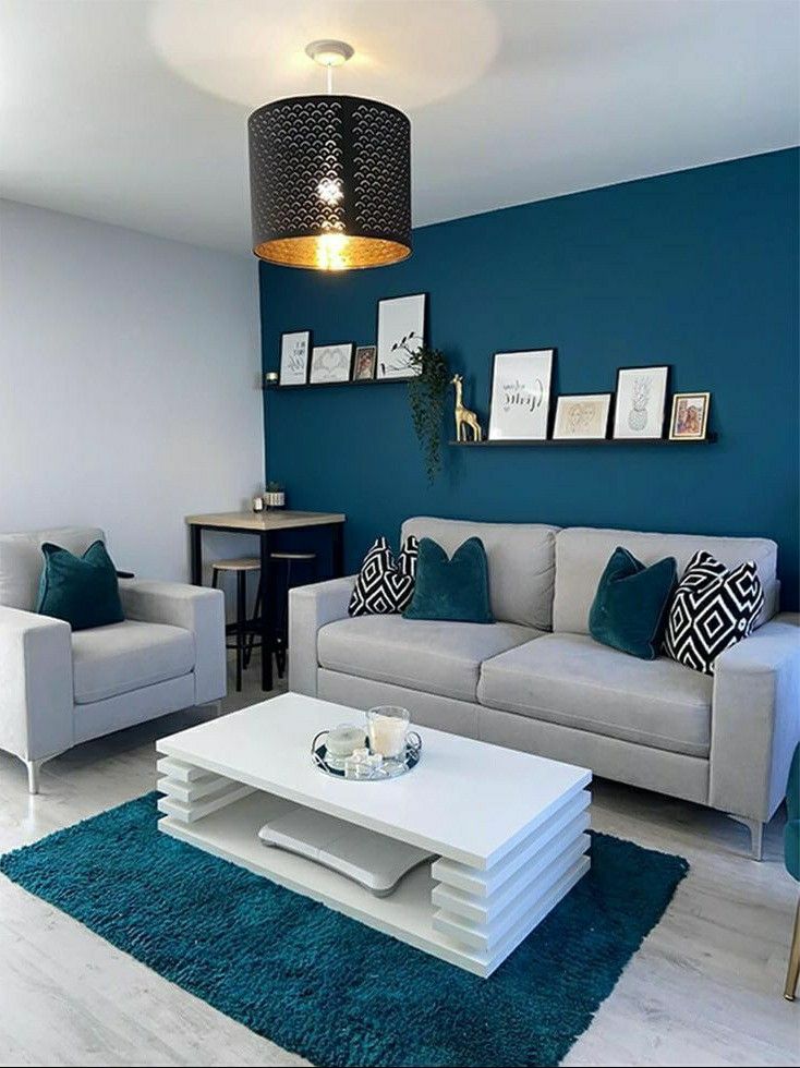 a living room with blue walls and white furniture