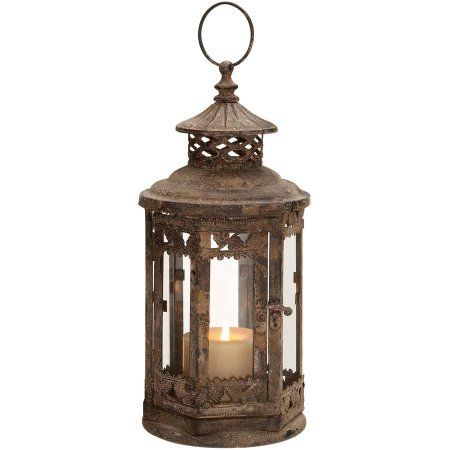 an old fashioned lantern with a candle in it's center and filigreet around the top