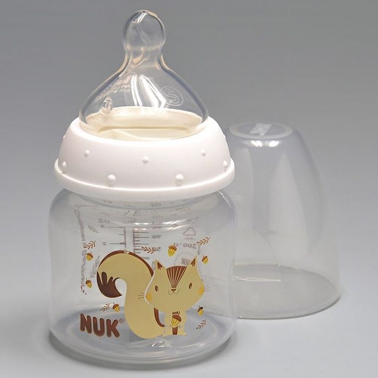 a baby bottle with a dummy in the top and an infant pacifier next to it