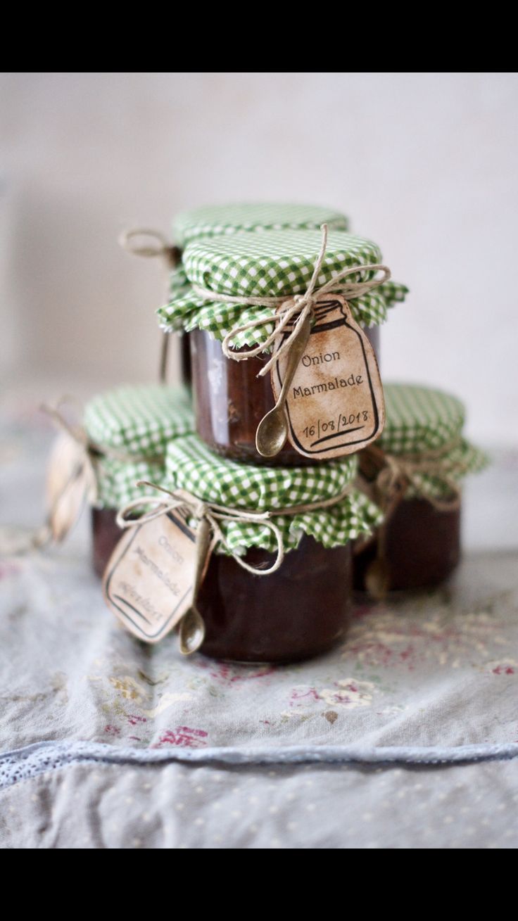 three jars filled with jam sitting on top of a cloth covered tablecloth next to each other