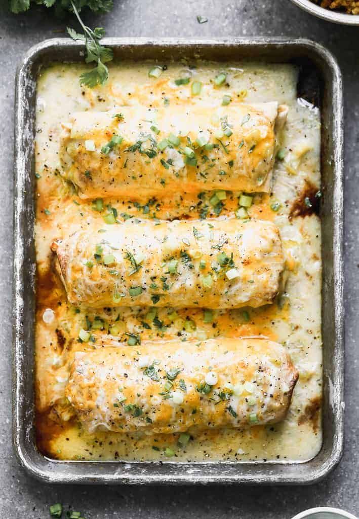 baked enchiladas in a baking pan with cheese and herbs