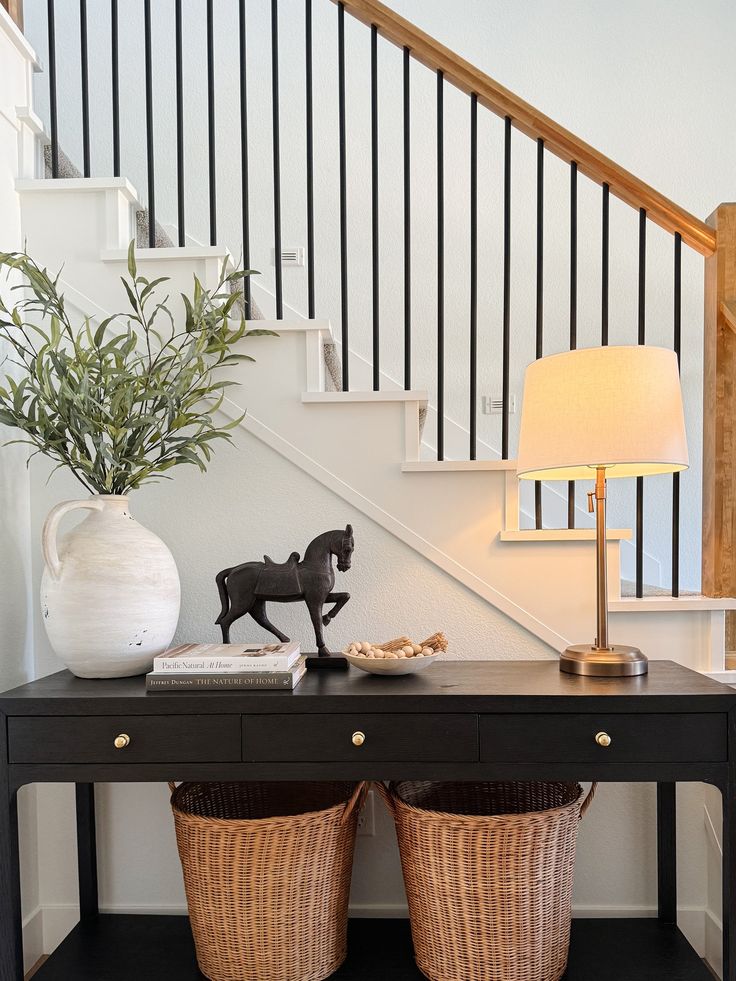 a black table with two baskets underneath it and a lamp next to it on the side