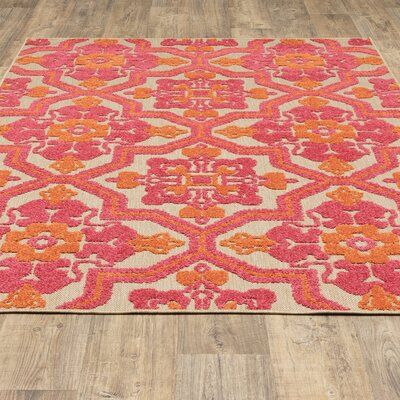 an orange and pink rug on a wooden floor