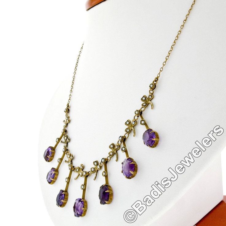 "You are looking at a rare antique collier necklace crafted in solid 14k yellow gold during the Victorian era. The center part of this beautiful necklace features elegant fringe designs alternating with clover leaf accents throughout. Each of these 7 dangle parts is set at its bottom with an old oval cut amethyst stone that shows amazing, rich purple color, and all 7 of them total approximately 14 carats in weight. The top of these fine gemstones, as well as the pretty leaf designs, are adorned Antique Round Purple Necklace, Antique Oval Gemstone Necklace, Antique Amethyst Jewelry Stamped 14k, Antique 14k Stamped Necklaces For Formal Occasions, Victorian Purple Necklace For Anniversary, Antique Oval Purple Necklaces, Antique Oval Purple Jewelry, Antique Purple Oval Necklaces, Vintage Amethyst Yellow Gold Necklace