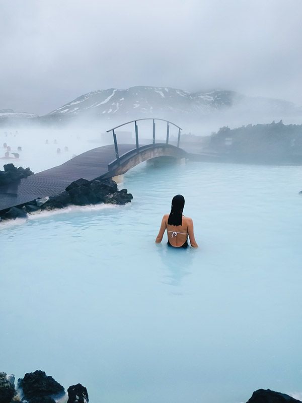 a woman sitting in the middle of a blue lagoon