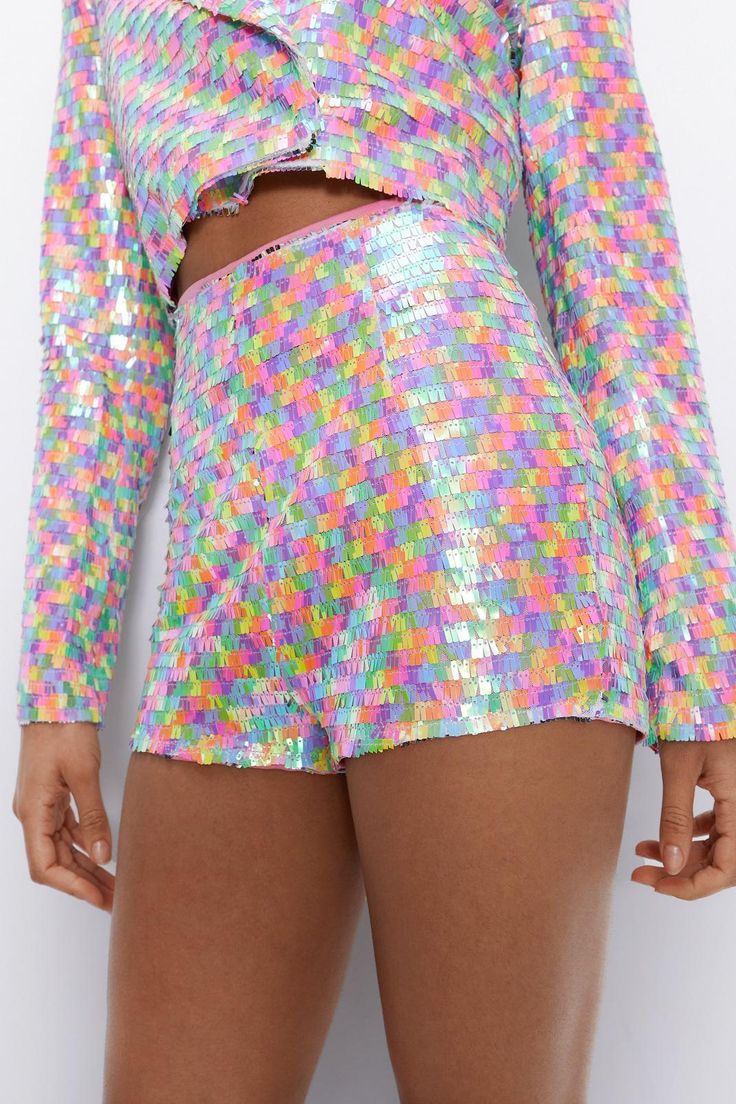 Where's the party? Feel fierce in our sequin shorts, made in shimmering sequin fabric, with a statement micro length and bodycon fit, and a fun rainbow colorway. The high waistline ensures your comfort and an ultra flattering fit, while the micro length and bodycon fit will turn heads. Pairs well with the matching sequin cropped blazer, or with a crop top for a more pared down approach. Perfect for discoball dancefloors, festival weekends, pride events, and rave nights. Multicolor Sequin ... Disco Stretch Shorts, Disco Style Stretchy Shorts, Fitted Multicolor Party Shorts, Disco Style Stretch Shorts, Party Pants With Built-in Shorts, High Waist Shorts For Spring Party, Disco Style Stretch Summer Shorts, Disco Style Multicolor Party Bottoms, Multicolor Disco Party Bottoms