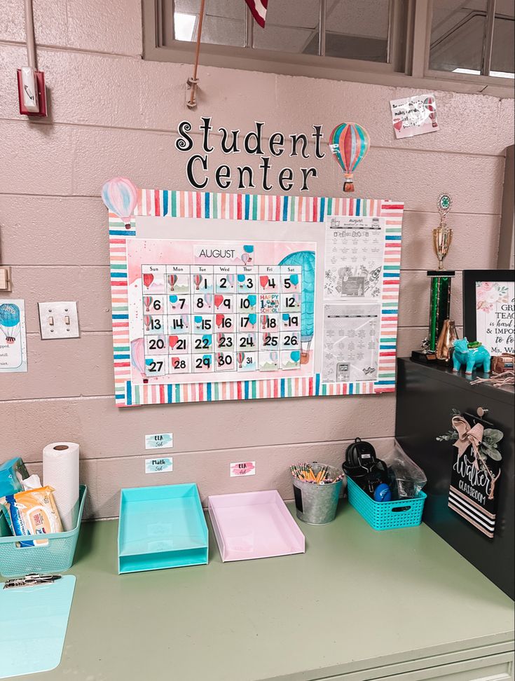 a bulletin board on the wall above a desk with drawers and other items in front of it