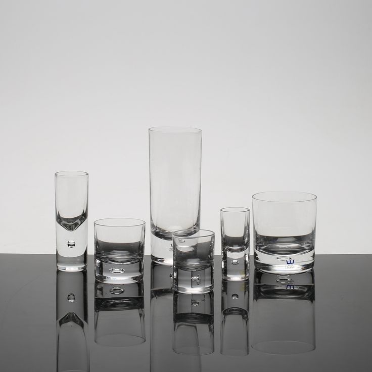 four glasses sitting on top of a table with one empty glass next to the other