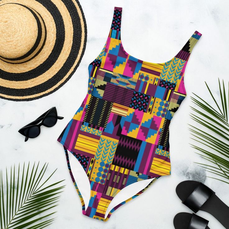 Royal Kente Print One-Piece Swimsuit, African Print bathing suit, Ankara Swimwear, Vibrant Colored Beachwear This one-piece swimsuit for all figures will bring out your best features. Enjoy the smooth fabric and the flattering design, and show it off by the sea or pool! * 82% Polyester, 18% Spandex * Fabric weight: 6.61 oz/yd² (224 g/m²) * Chlorine-resistant fabric * Cheeky fit with a scoop neckline and a low scoop back * Zig-zag stitching * Double-layer front  * Four-way stretch material stretc Tropical Multicolor Bodysuit For Pool, Bold Print Beachwear For Sunbathing, Tropical Multicolor Bodysuit For The Beach, Fitted Swimwear With Bold Print For Sunbathing, Fitted Multicolor One-piece For Sunbathing, Multicolor Tropical One-piece Swimwear, Multicolor One-piece Bodysuit For The Beach, Multicolor Beachwear One Piece For Swimming, Tropical Multicolor One-piece Swimsuit