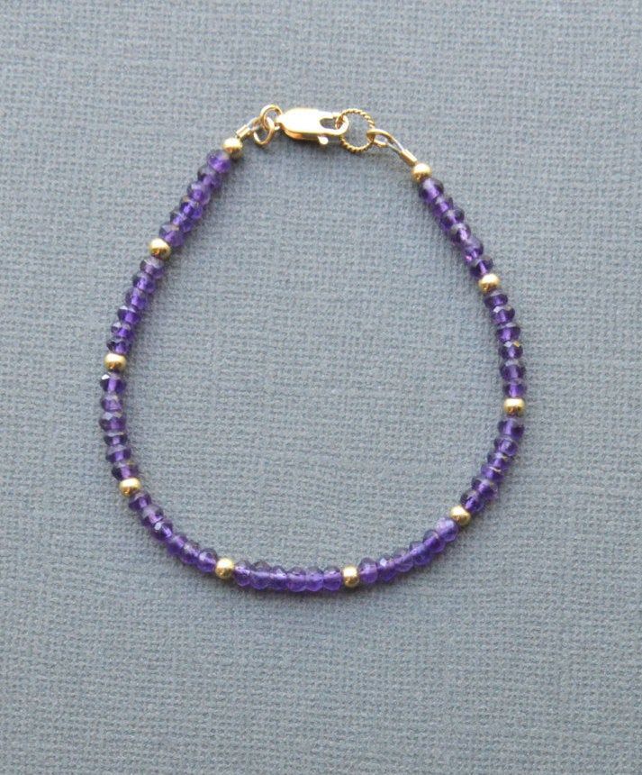 "Amethyst Bracelet Sparkling purple and gold....what's not to like? Genuine amethyst rondelles encircle this bracelet, which is interspersed with 14K gold filled beads. Lobster clasp closure with pretty rope detail ring at clasp. Fashioned on professional quality beading wire for strength and flexibility. A nice addition to your collection. You know -- the one that keeps growing. Unashamedly. Bracelet collectors unite! Faceted rondelles of genuine amethyst, about 3.5-4mm All components 14K gold Purple Tiny Beads Beaded Bracelets As Gift, Dainty Purple Beaded Bracelets With Round Beads, Dainty Purple Beaded Bracelet With Round Beads, Lavender Jewelry With Tiny Beads For Gifts, Dainty Purple Beaded Bracelet, Dainty Purple Jewelry With Tiny Beads, Dainty Purple Beaded Jewelry, Adjustable Amethyst Beads For Jewelry Making, Elegant Purple Beaded Bracelets With Tiny Beads