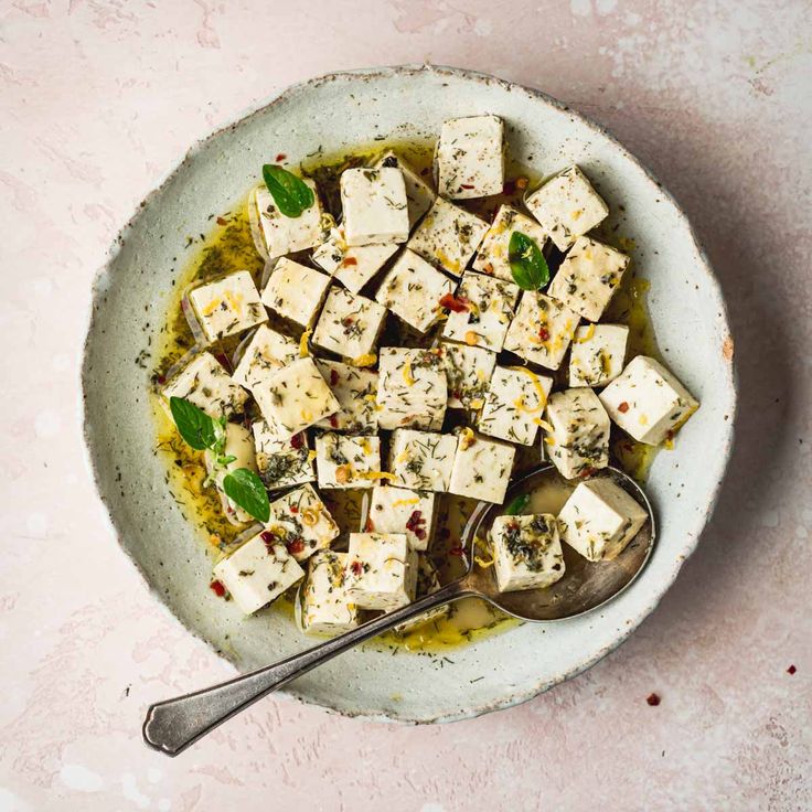 a white bowl filled with tofu and olive oil