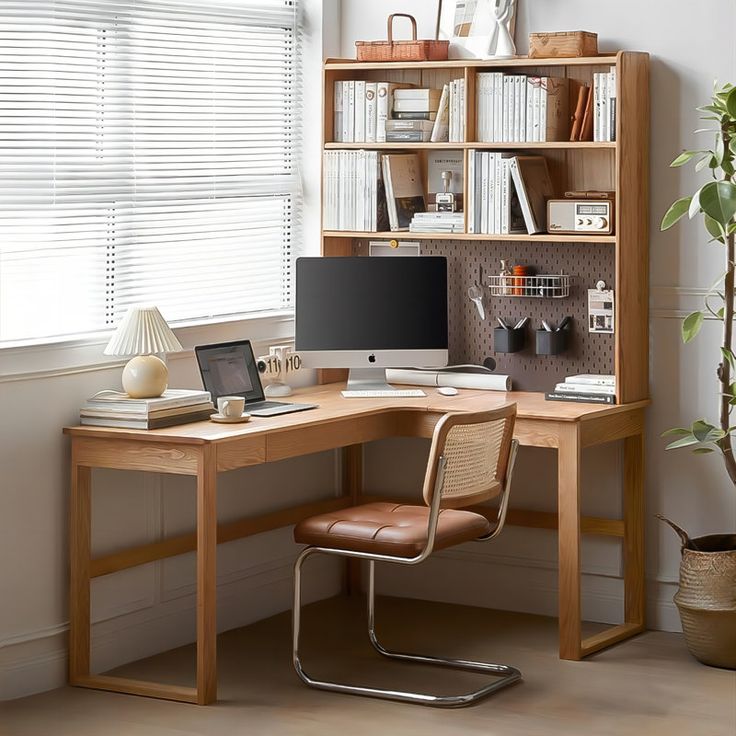 a desk with a laptop computer on top of it next to a book shelf filled with books