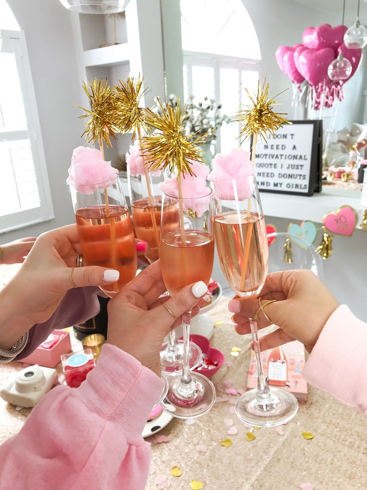 three people toasting with champagne glasses at a table filled with confetti and decorations