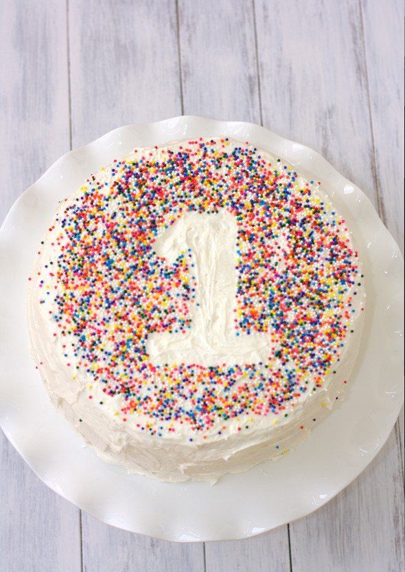 a birthday cake with sprinkles on it and the number one frosted in white