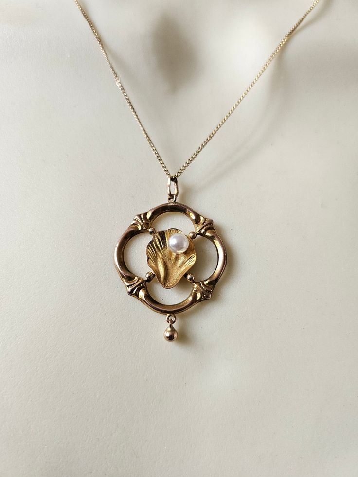 An absolutely glorious vintage necklace.  Hallmarked 9ct gold.  Art Nouveau in style, dating to around the 1960s. Delicate, exquisite details, with a sweet dangling ball drop. Reminds me of the birth of Venus, or something that would adorn a mermaid.  All solid 9ct gold. The pearl is a faux pearl. I am happy to replace with a genuine freshwater pearl if you prefer.  Chain: 16 inches Pendant: a little over 2cm wide  Rare & special ~ Vintage Pearl Charm Jewelry For Anniversary, Vintage Jewelry With Pearl Charm For Anniversary, Vintage Gold Pearl Necklace With Pearl Drop, Vintage Gold Pearl Drop Necklace, Vintage Jewelry With Pearl Charm Round Pendant, Gold Art Deco Necklace With Pearl Pendant, Heirloom 14k Gold Necklace With Pearl Pendant, Vintage Pearl Drop Pendant Jewelry, Vintage Round Pearl Drop Jewelry