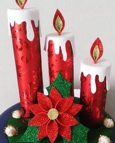 three candles with red and green decorations on top