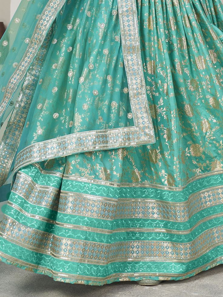 Introducing our captivating sea green zari embroidered jacquard lehenga choli, a stunning ensemble that is sure to make you stand out at any wedding or special occasion. This beautiful lehenga features intricate zari embroidered work and sequin embellishments, adding a touch of glamour and elegance to your look.
The sea green color of the lehenga is absolutely mesmerizing, creating a striking and eye-catching appearance. The jacquard fabric adds a luxurious touch to the outfit, giving it a rich Green Lehenga With Intricate Embroidery For Festive Occasions, Festive Green Lehenga With Intricate Embroidery, Bollywood Green Lehenga With Intricate Embroidery, Turquoise Anarkali Lehenga With Pallu, Designer Turquoise Lehenga With Dupatta, Anarkali Style Turquoise Lehenga With Pallu, Designer Turquoise Lehenga With Pallu, Turquoise Anarkali Lehenga With Zari Work, Turquoise Lehenga With Zari Work For Navratri