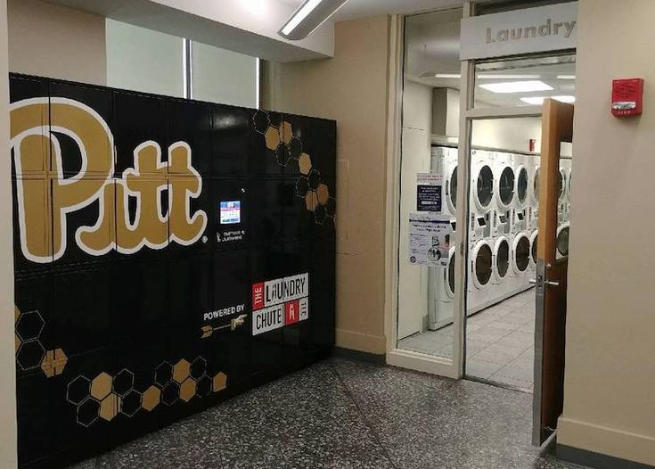 the entrance to a laundry facility with signs on the wall and dryer machines in the background