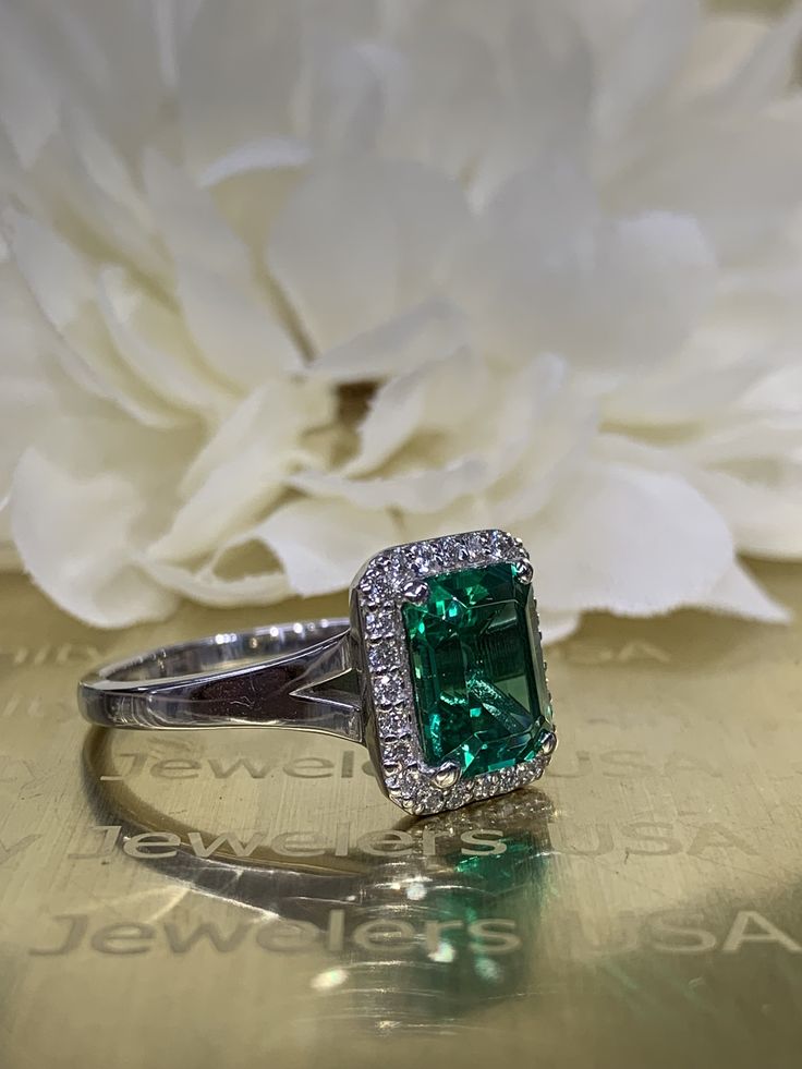 This ring is an emerald cut lab created green emerald with genuine diamond halo made with solid 14k white gold item #5457 We feature the finest quality lab grown emeralds in the world. The properties of lab-grown are physically, chemically and visually identical to natural, just grown in a lab setting. Emerald is the birthstone of May -Approximate total carat weight: 2.75ctw diamond equivalent -Center Stone Size: approx. 2.50ct diamond equivalent -Center Stone Shape: emerald cut 9x7mm -Gem Type: Classic Emerald Halo Ring Gia Certified, Classic Green Halo Ring With Diamond Accents, Classic Gia Certified Emerald Halo Ring, Green Brilliant Cut Platinum Halo Ring, Green Emerald Ring With Diamond Accents In Platinum, Platinum Emerald Ring With Diamond Accents, Emerald Ring With Halo Setting In Platinum, Classic 14k White Gold Green Diamond Ring, Green Emerald Ring With Halo Setting In Platinum