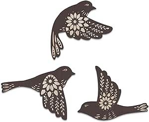 three birds flying in the air with flowers on their wings