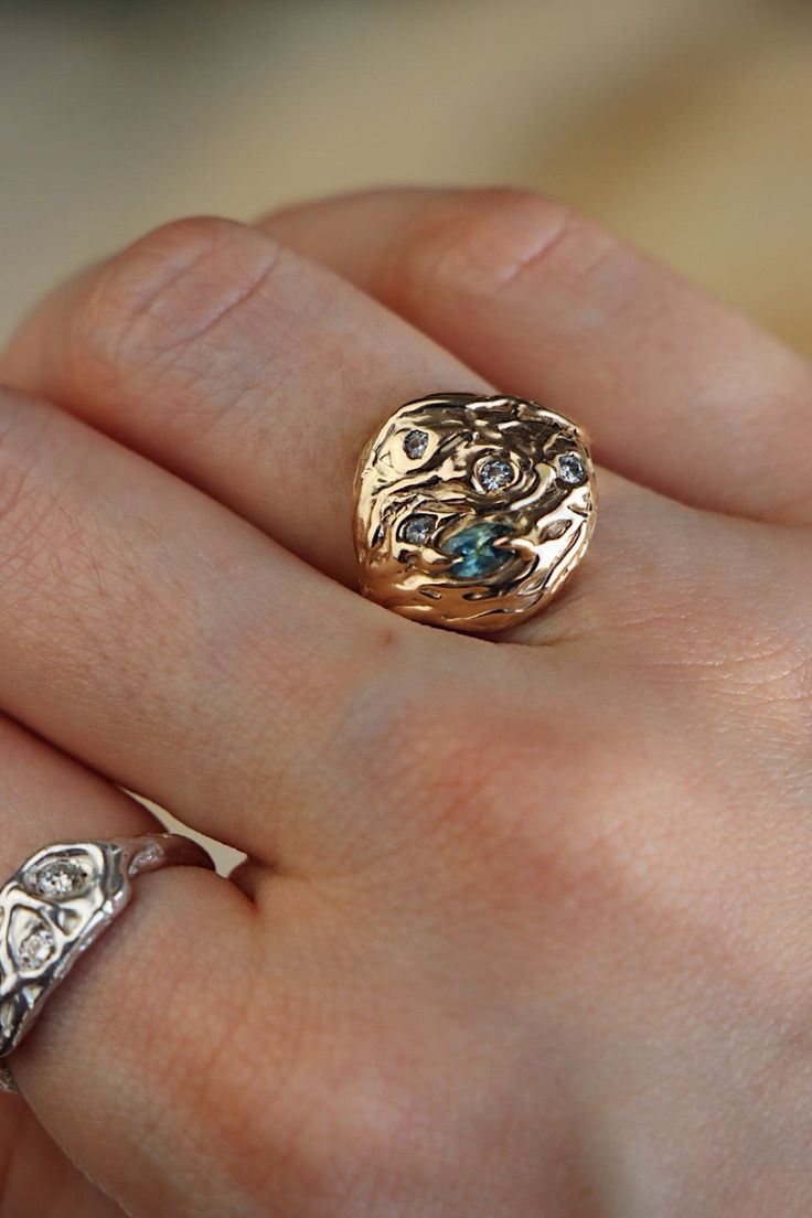 a close up of a person's hand with a ring on it