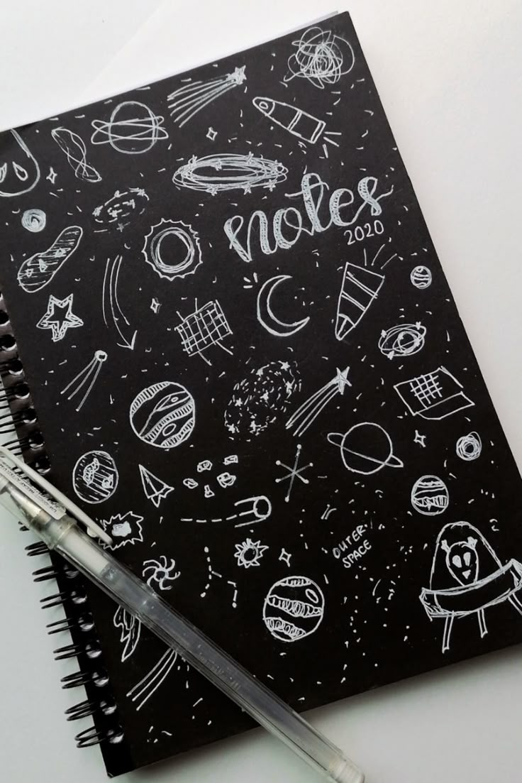 a notebook with doodles on it and a pen next to the page that says notes