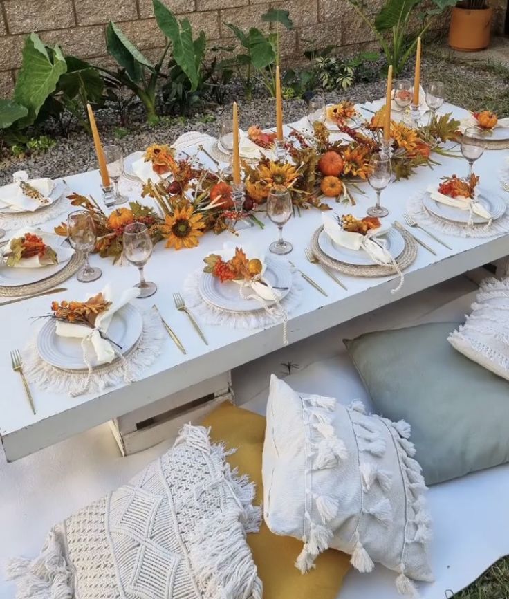 a table set up with plates and place settings for an outdoor dinner party or gathering