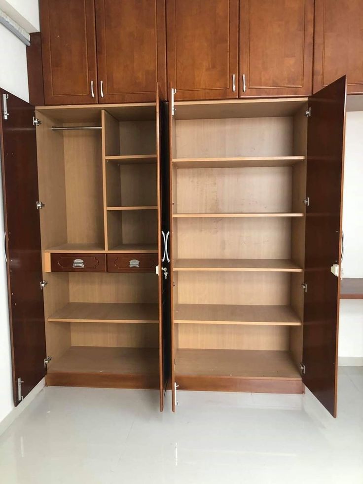 an empty closet with wooden shelves and drawers