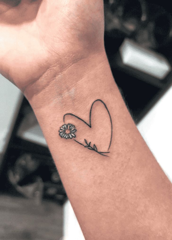 a small tattoo on the wrist of a person with a flower in its heart shape