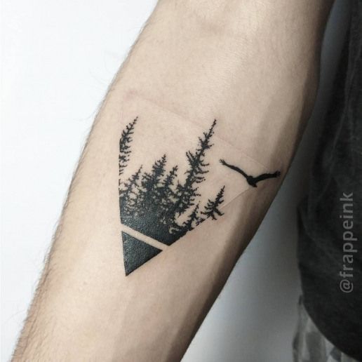 a man's arm with trees and an eagle tattoo on the left side of his arm