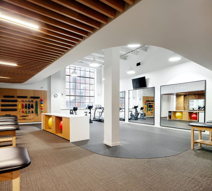 the inside of a gym with mirrors and exercise equipment in it's center area