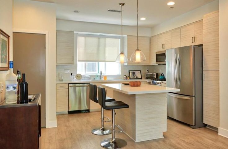 a modern kitchen with stainless steel appliances and wood flooring