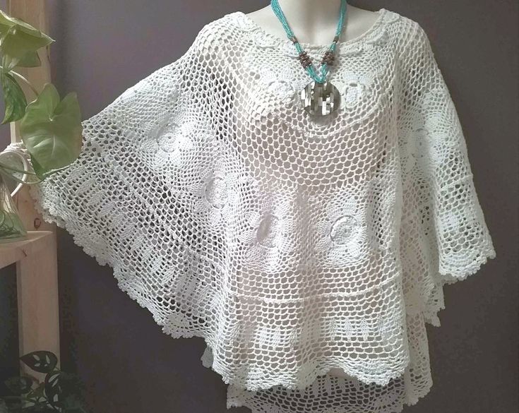 Bohemian groovy Crochet poncho ! A beautiful white crochet poncho. Up cycled from a oval vintage cotton crochet table cloth. Slips over the head and drapes beautifully. Crochet trim sewn around the neck line ! The table cloth is in great condition no holes or wear. Necklace NOT included. Free size  Longer at the back , shorter at the front. 22 inches long from neck line at front   ..   56 cm 26 inch long from neckline at back  ..  86 cm for more of my ponchos, click here https://www.etsy.com/au/ Bohemian Handmade Crochet Top For Festivals, Handmade Bohemian Crochet Top For Festivals, Handmade Bohemian Crochet Top For Beach Cover-up, Bohemian Hand Knitted Poncho For Beach, Hand Knitted Bohemian Poncho For Beach, Spring Crochet Poncho Shawl, Handmade Bohemian Crochet Top, White Handmade Bohemian Crochet Top, One Size Hippie Crochet Poncho