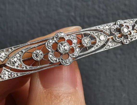 A beautifully elegant bar brooch, set with multiple diamonds in floral motifs, in an openwork setting, mounted in 18ct yellow gold and platinum, with a pin and hinged catch. A wonderful statement piece from the Edwardian period.Circa 1910.The length of the brooch measures approximately 77mm.The width of the brooch measures approximately 9.5mm (at the widest point) to 3.5mm (at the slimmest point).The approximate weight is 7.1 grams.CONDITION: Overall very good, with some light wear commensurate Elegant Bar, Bar Brooch, Diamond Bar, Small Rings, Diamond Fashion, Favorite Rings, Floral Motifs, Gold Pearl, Rose Cut