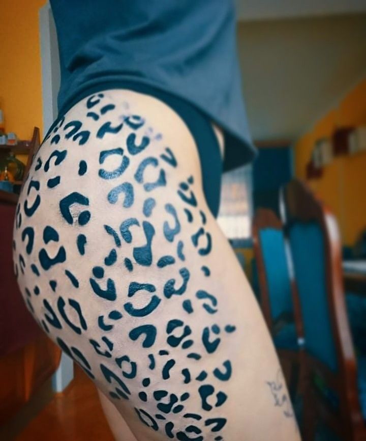 a woman's leg with black and white leopard print on the side of her body