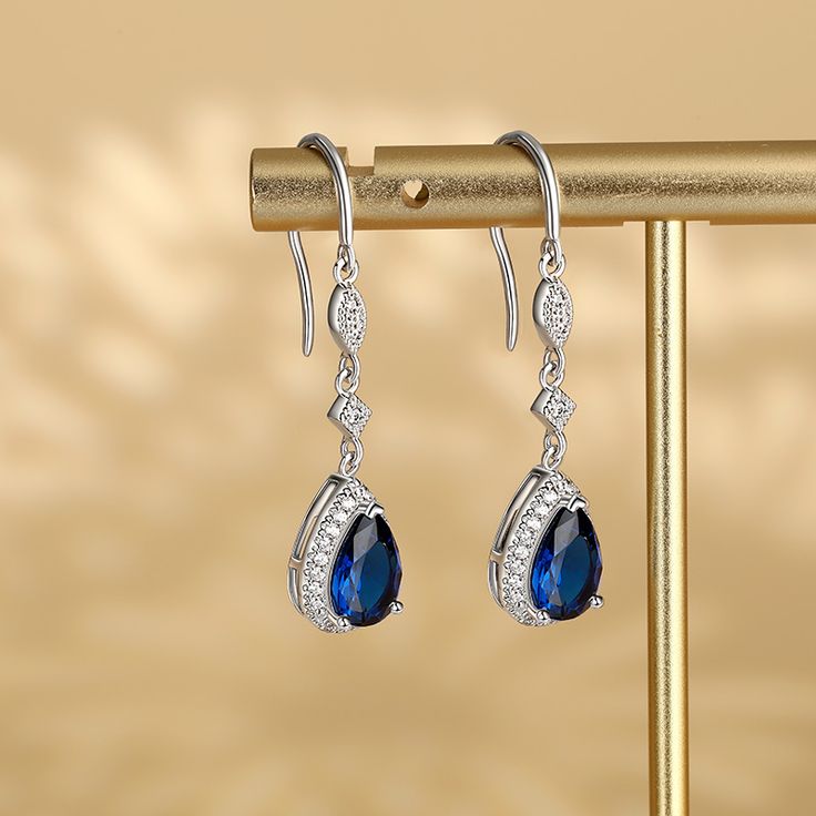 Polished metal and sparkling stones come together to create this unique jewelry, giving it a sophisticated and sparkling look. Made from sterling silver, these earrings make a stunning fashion accessory.Carat Weight: 2.77 ctStone Size: 6*9 mmStone Type: Jeulia® StoneNumber of Stones: 2 Stone Shape: PearStone Color: Sapphire BlueCarat Weight: 0.552 ctStone Size: 1.2,1,0.8 mmStone Type: Jeulia® StoneNumber of Stones: 56 Stone Shape: RoundStone Color: Diamond WhiteWeight: 2.95 gWidth: 8.8 mmHeight: Luxury Sterling Silver Pear-shaped Earrings, Luxury Pear-shaped Sterling Silver Earrings, Diamond Teardrop Crystal Earrings With Diamond Accents, Elegant Teardrop Crystal Earrings In Diamond White, Elegant Teardrop Diamond Earrings Fine Jewelry, Teardrop Diamond Earrings With Elegant Design, Elegant Teardrop Diamond White Crystal Earrings, Sapphire Dangle Crystal Earrings For Formal Occasions, Sapphire Crystal Dangle Earrings For Formal Occasions