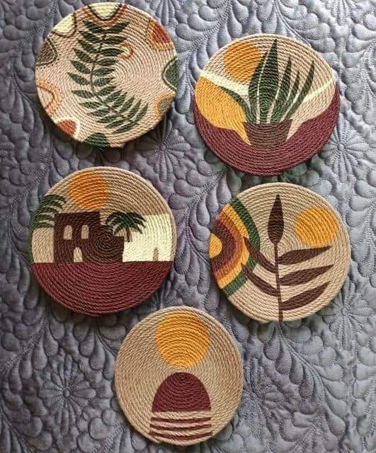 four woven coasters with different designs and colors on the top one has a house, palm tree, and sunset