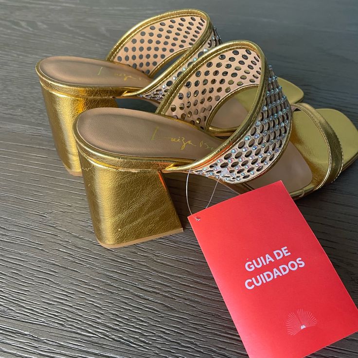 Brand New Brazilian Designer Luiza Barcelos. Size 9us. Chic Gold Mules With Stacked Heel, Gold Closed Toe Sandals For Night Out, Gold Low Heel Summer Heels, Gold Round Toe Sandals For Night Out, Summer Party Mules With Ankle Strap, Gold Block Heel Mules For Summer, Gold Sandals With Removable Insole For Parties, Gold Mules With Stacked Heel, Gold Mules With Stacked Heel For Spring