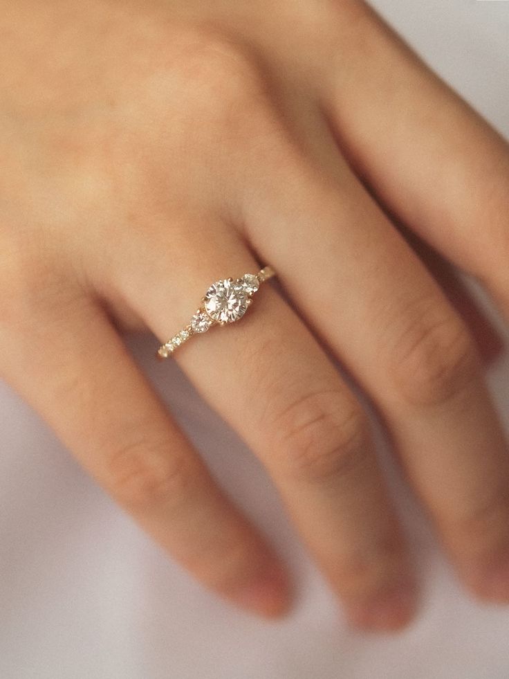 a woman's hand with a diamond ring on it