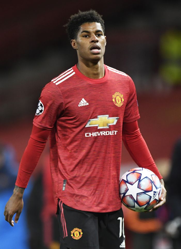 a man holding a soccer ball in his hand and wearing a red shirt with the manchester united logo on it