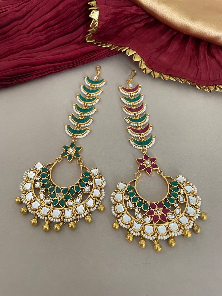 Add a touch of sparkle to your bridal look in our enchanting kundan maang tika! Beautiful head jewelry showcasing kundan and pearl moti with intricate meenawork. Colour Options: Green Red and Green Detailss: Length-6 Inches Width-2.25 Inches All products are manufactured using traditional skills from our rich heritage of crafts.  The process of these crafts is essentially manual. Hence, any irregularities or variations are an inherent part of these handcrafting processes. Maang Tika, Headpiece Jewelry, Head Jewelry, Jewelry Showcases, Hair Jewelry Wedding, Wedding Jewellery, Body Jewellery, Indian Jewellery, Bridal Looks